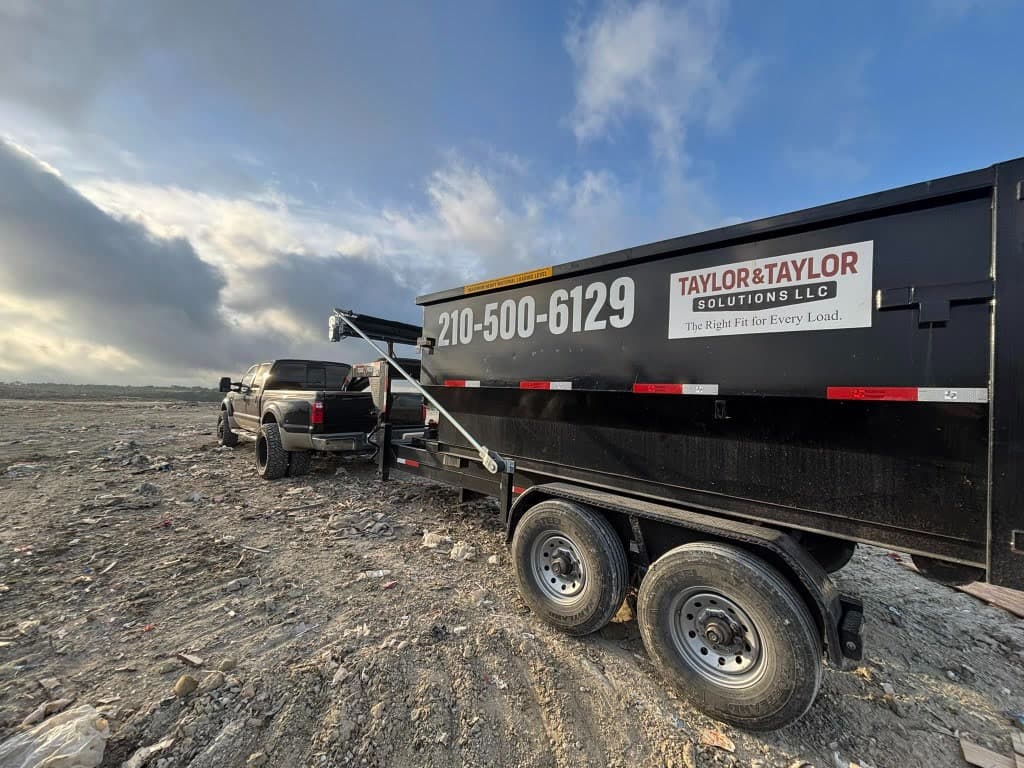 Taylor & Taylor dumpster trailer hitched to a black work truck