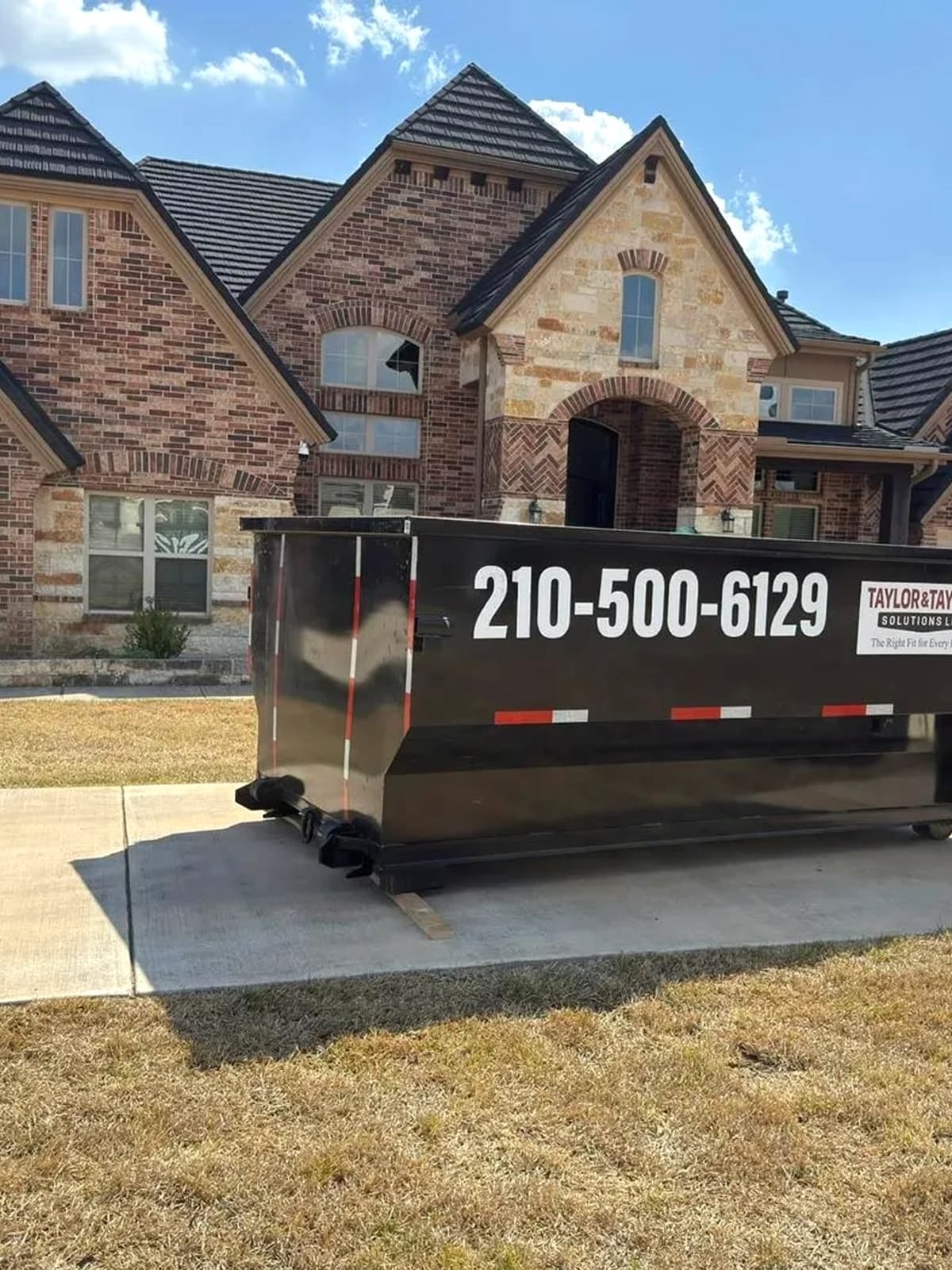 Taylor & Taylor dumpster delivered to a residential driveway in front of a home